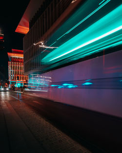 Illuminated trail of tram in city at night