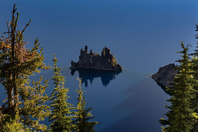 Panoramic view of rocks and trees against clear blue sky