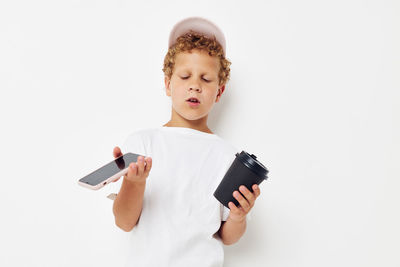 Young woman using mobile phone against white background