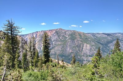 Scenic view of mountains against blue sky