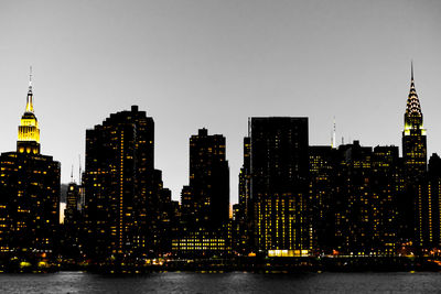 Illuminated buildings in city against sky