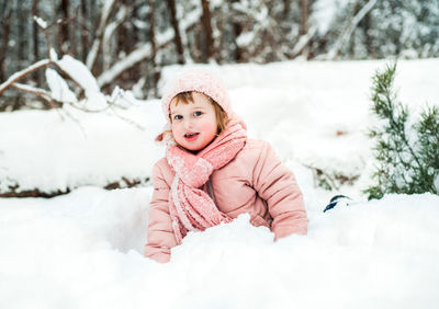 Portrait of cute girl playing with snow during winter