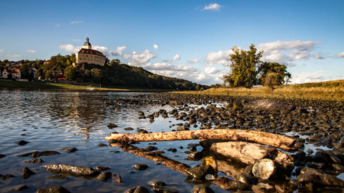 Scenic view of river by building against sky
