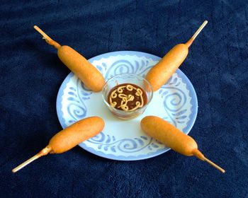 Corn dogs on plate.