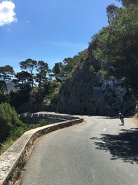 Rear view of man cycling on mountain road