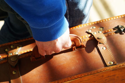 Cropped image of person holding suitcase