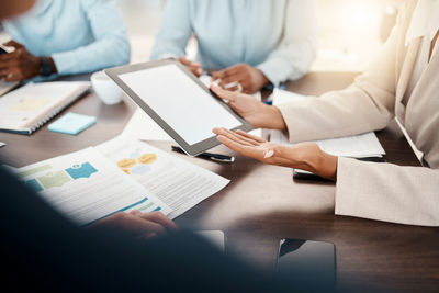 Midsection of business colleagues working at desk in office