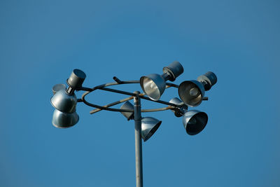 Low angle view of floodlight against clear blue sky