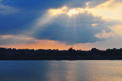 Scenic view of river against sky at sunset