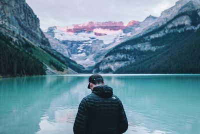 Rear view of man on snowcapped mountains against sky