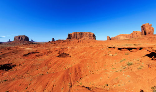 Rock formations on landscape against clear blue sky