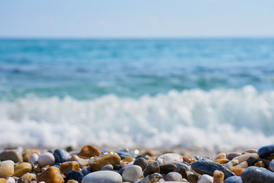 Surface level of stones on beach against sky