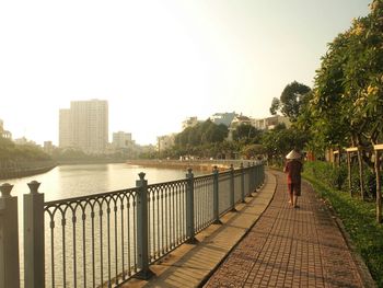 Rear view of person wearing traditional hat while walking by river