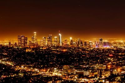 Illuminated cityscape against sky at night