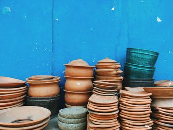 Clay bowls for sale against blue wall
