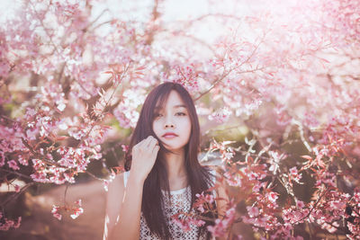 Young woman holding cherry blossoms in park