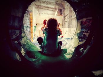 Rear view of girl sitting in slide