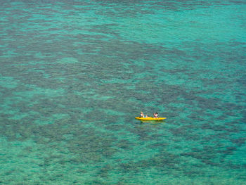 High angle view of women sitting canoe at sea