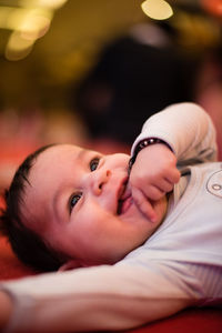 Close-up of cute happy baby boy lying at home