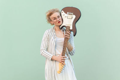 Portrait of woman standing against blue background