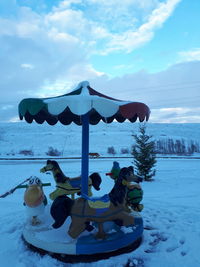 People on snow covered land against sky