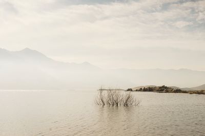 Scenic view of sea and mountains against sky