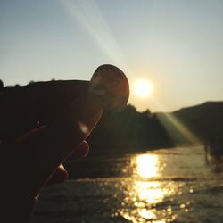 Silhouette of person in sea during sunset