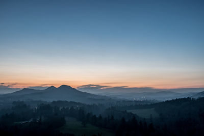 Scenic view of silhouette mountains against sky at sunset