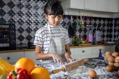 Cute girl preparing food at kitchen