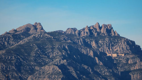 Panoramic view of rocky mountains against clear sky