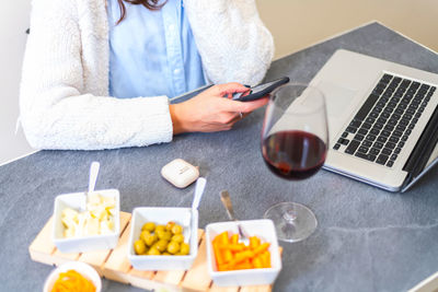 Midsection of man using mobile phone on table