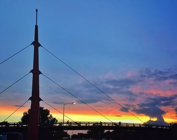 Silhouette of power lines against cloudy sky