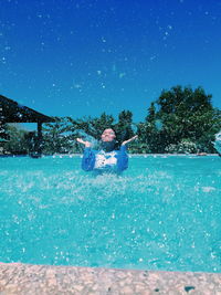 Woman splashing water in swimming pool