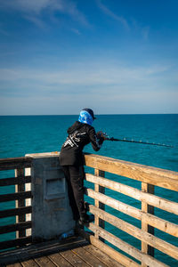 Rear view of woman looking at sea against sky