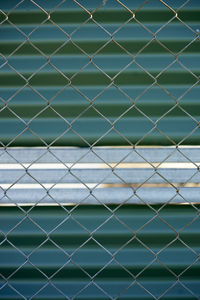 Full frame shot of chainlink fence against shutter