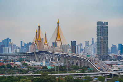 Bridge and buildings in city against sky