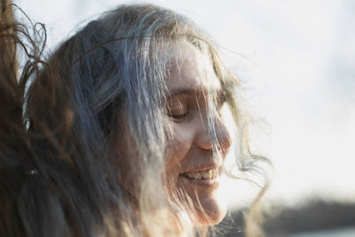 Close up tousled gray haired woman laughing with closed eyes portrait picture