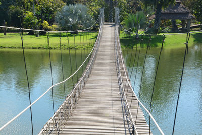 Footbridge over river against trees