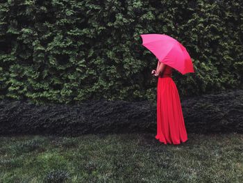 Red umbrella standing on field during rainy season
