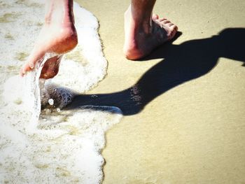 Low section of man legs on sand at beach