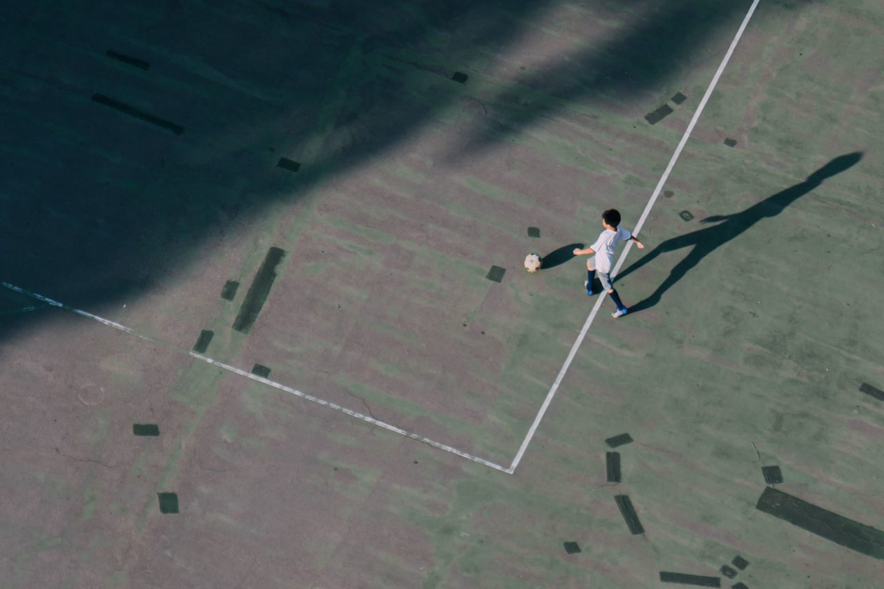 HIGH ANGLE VIEW OF PERSON WALKING ON STREET IN CITY