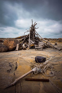 Old wooden structure on land against sky