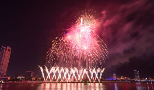 Low angle view of firework display at night