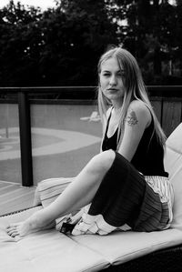 Young woman looking away while sitting outdoors