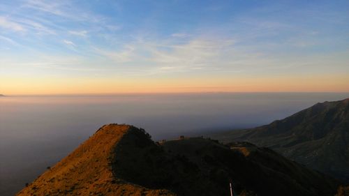 Scenic view of mountain against cloudy sky