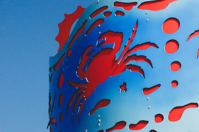 Low angle view of jellyfish in water against blue sky