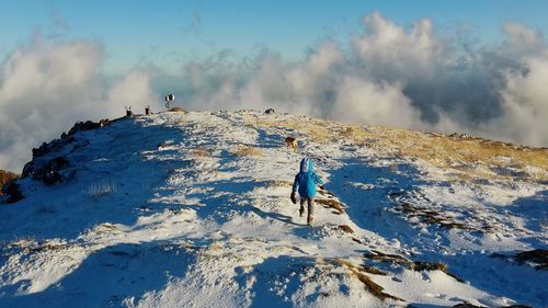 Scenic view of snow covered mountains against blue sky