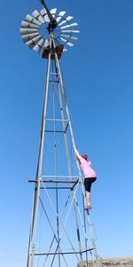 Low angle view of traditional windmill against clear blue sky