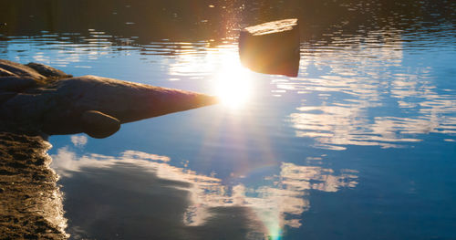 Reflection of man on puddle at sunset