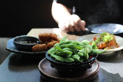 Cropped image of man eating food at table